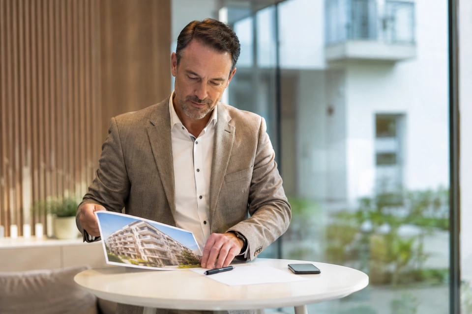 Symbolische Vorbereitung eines Immobilienkontakts am Stehtisch